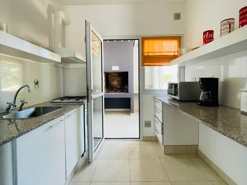 Cocina con puerta de vidrio hacia la parrilla