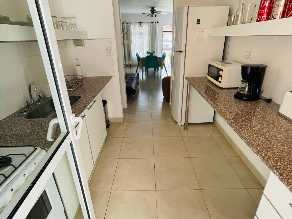 Cocina con mesada de granito, microondas, cafetera y heladera