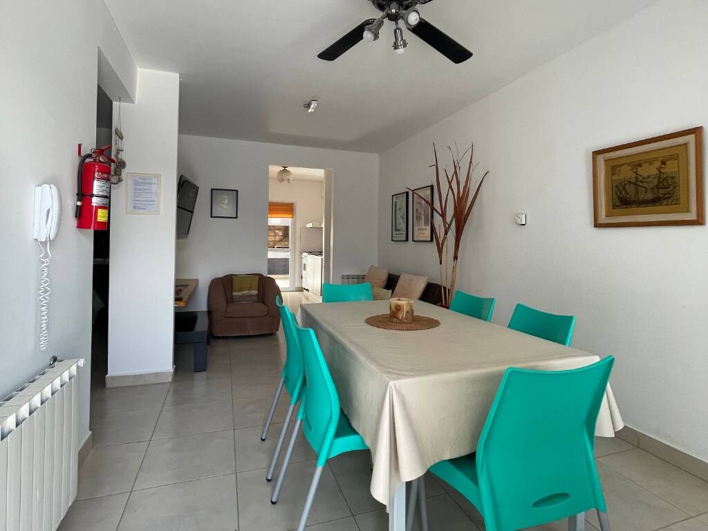 Mesa con sillas turquesa, sillón y ventilador de techo