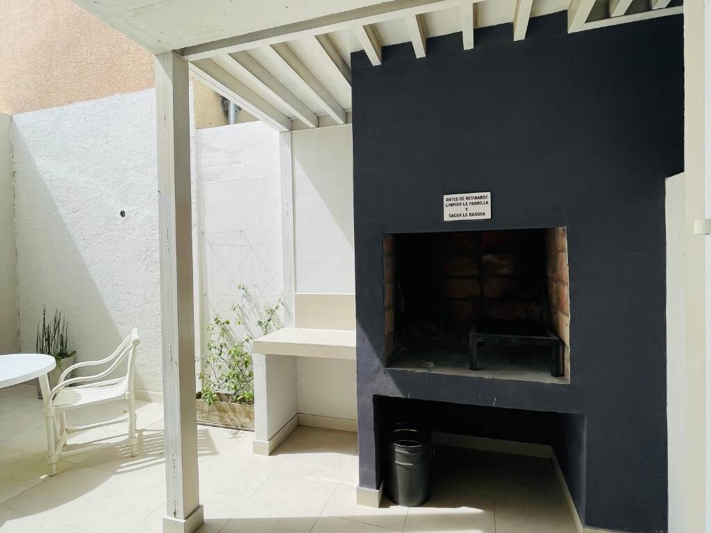 Parrilla de material bajo una pérgola en el patio
