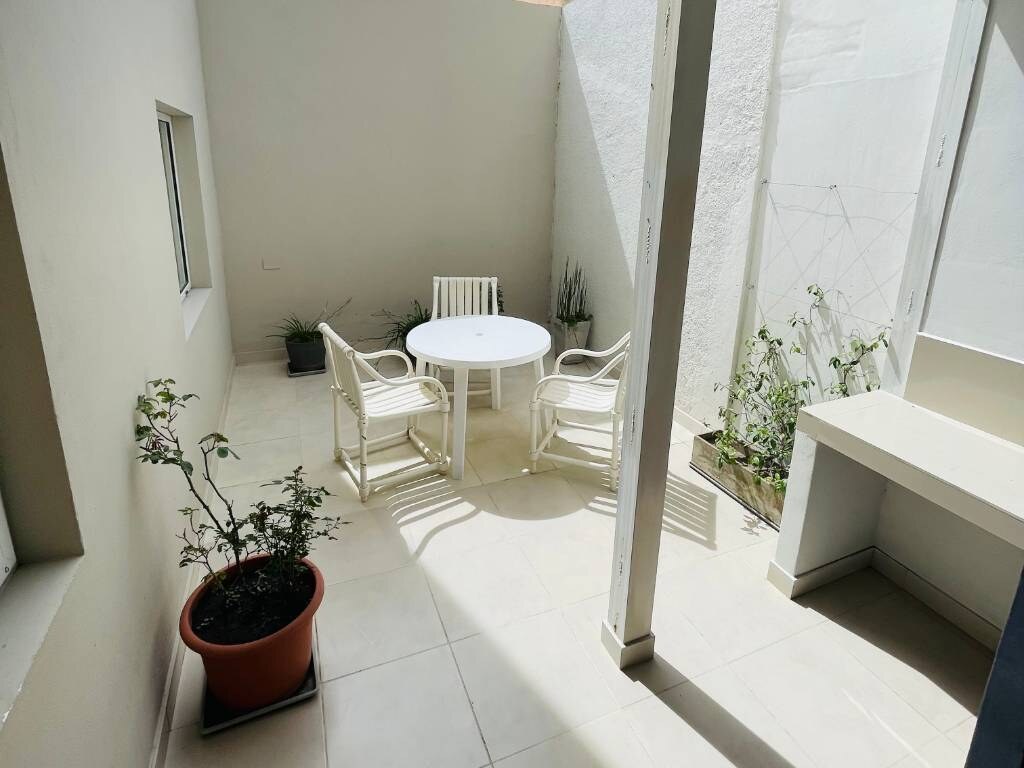 Patio con mesa redonda y sillas blancas